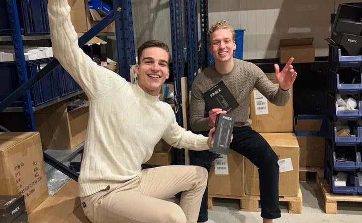The two FINEX founders in the warehouse holding the first video doorbell